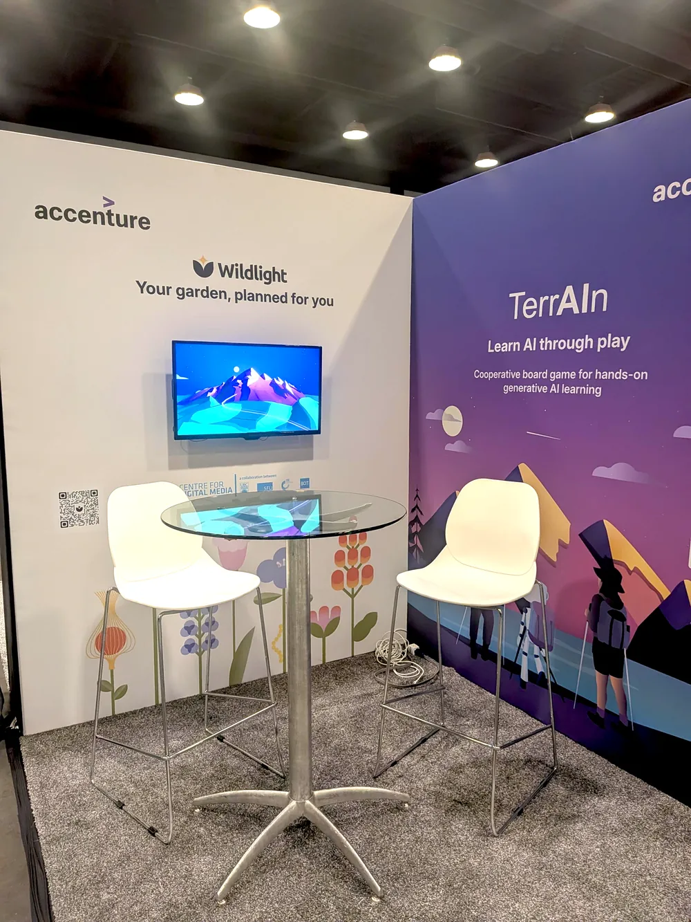 The Accenture and Wildlight booth at Web Summit, with a demo screen and two stools